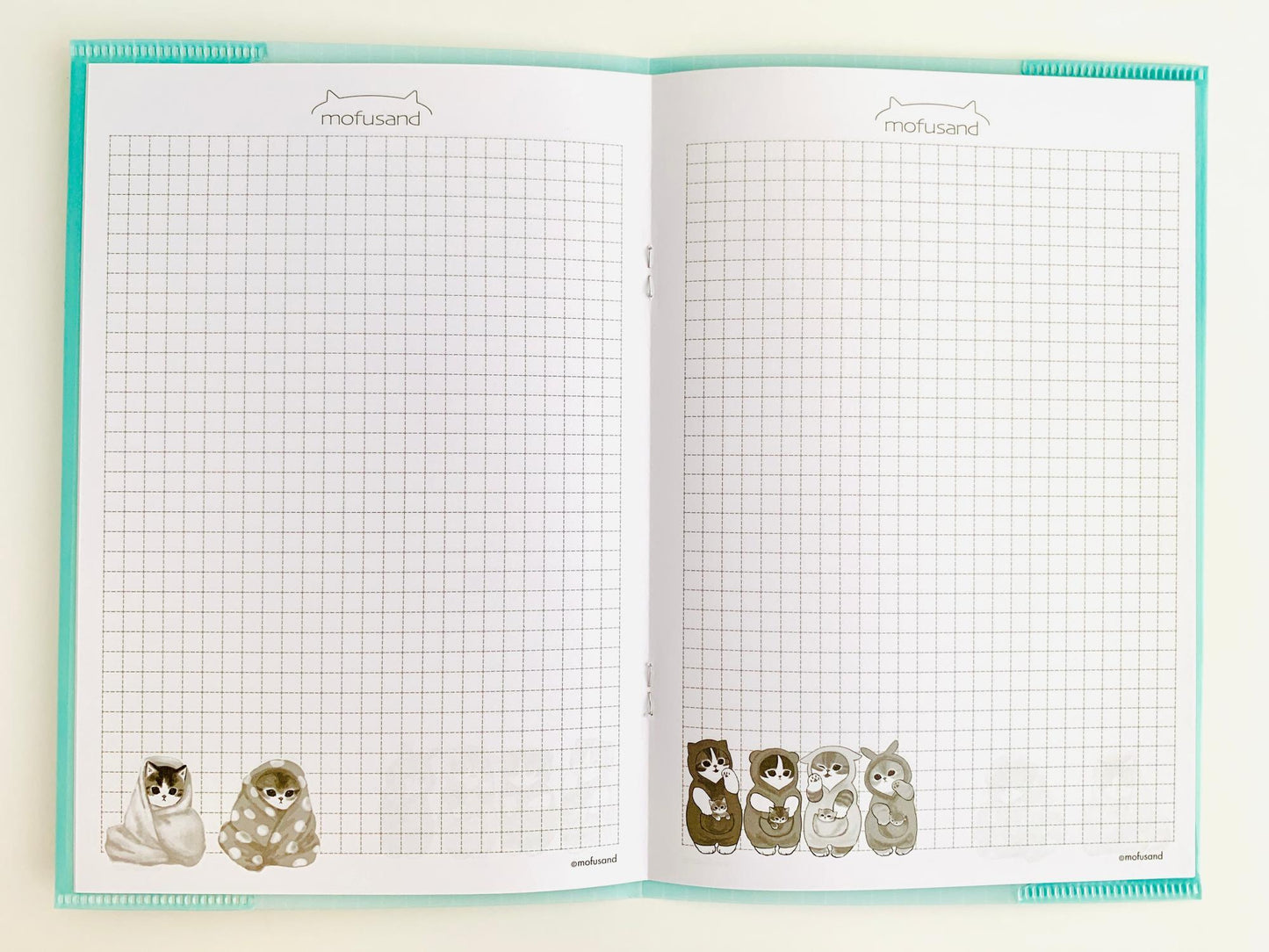 parte interna del cuaderno mofusand de gatitos saliendo de la hora de su ducha. rallado cuadriculado