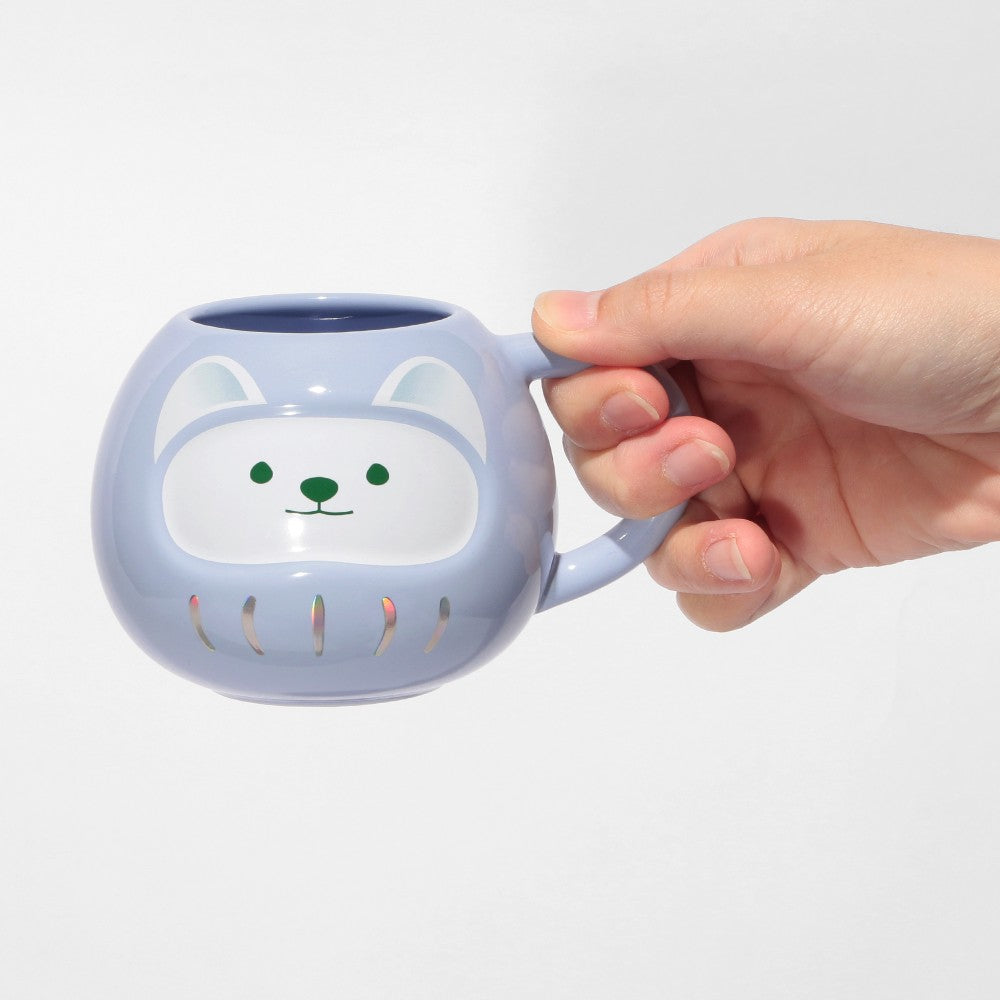 Persona sosteniendo la nueva Taza Daruma de Starbucks, edición limitada 2025.