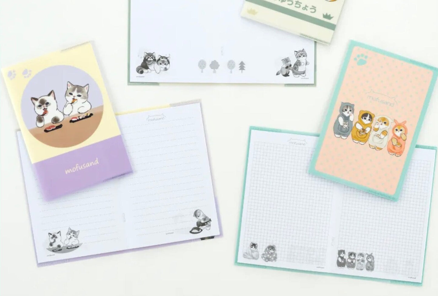 Set de carpetas y cuaderno de gatos de Mofusand con distintos diseños, los cuadernos están abiertos para más detalles