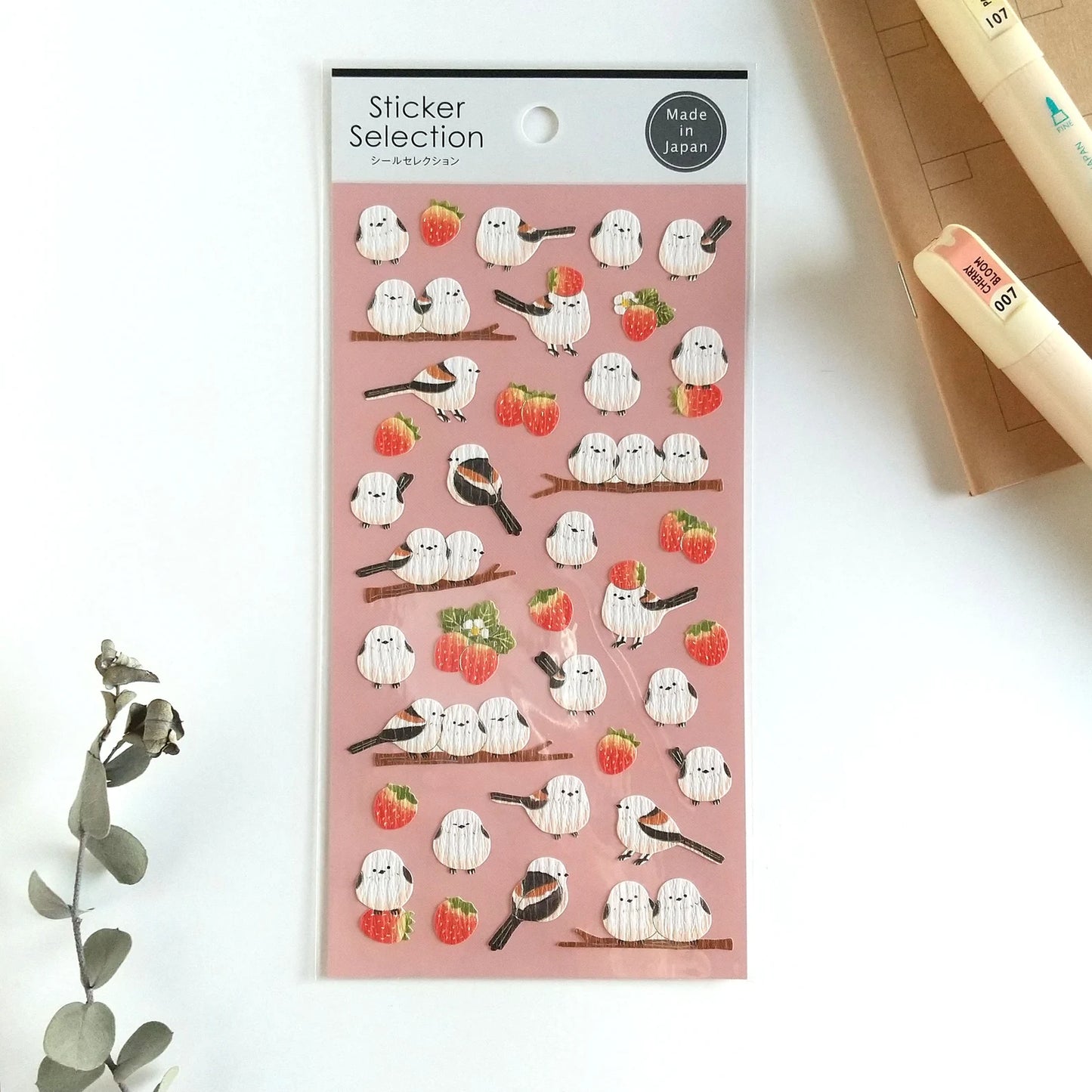 Pegatinas japonesas Gaia con ilustraciones de pajaritos blancos y marrones junto a fresas, sobre fondo rosado.